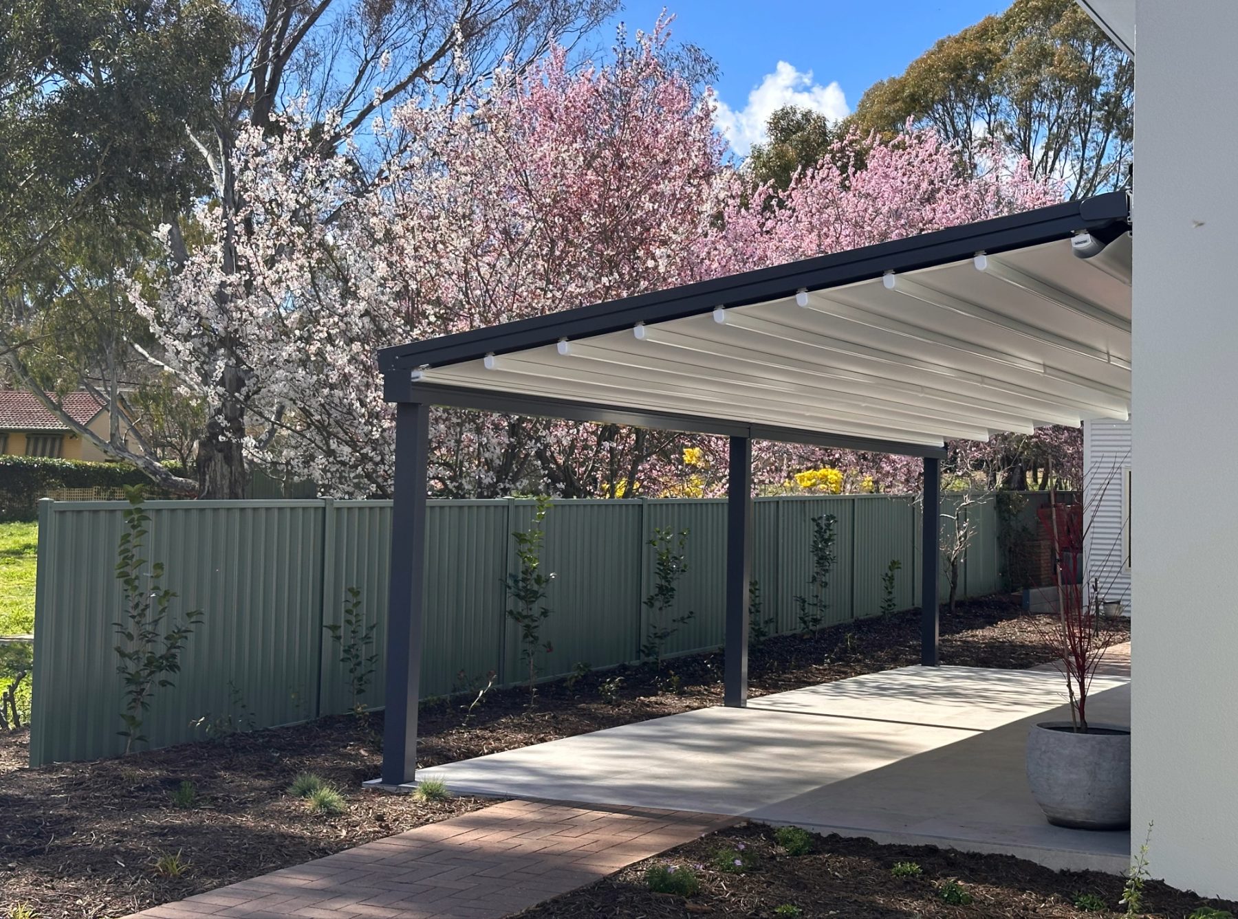 Helioscreen All Seasons retractable awning in closed position — twin-field configuration installed on a residential pergola in Watson ACT, showing the cassette housing and guide arms